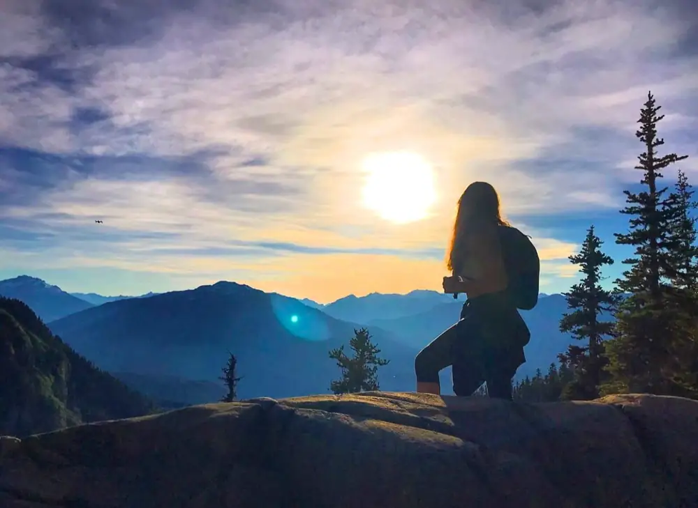 Kait looking out over mountain peaks at sunset